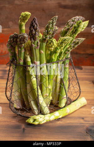 Köstliche Bündel roh reif grüner Spargel neue Ernte auf hölzernen Hintergrund Stockfoto
