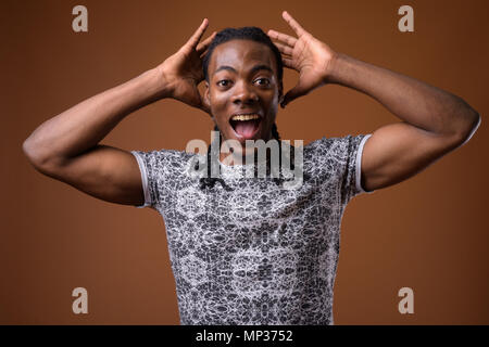Junge schöne afrikanische Menschen gegen den braunen Hintergrund Stockfoto