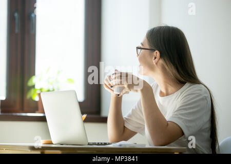 Lächelnde Frau suchen in Fenster in Arbeit Unterbrechung Stockfoto