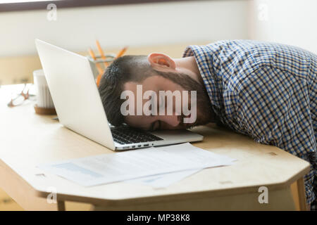 Müde männlichen Arbeitnehmer zu schlafen, Laptop im Büro Schreibtisch Stockfoto
