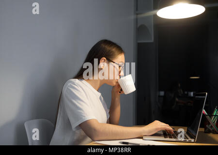 Weibliche Arbeitnehmer/in während der späten Arbeiten Stockfoto