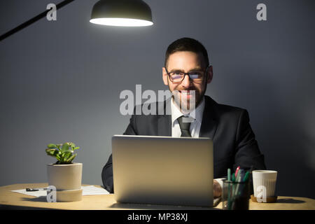 Glücklich Mann lächelt in die Kamera während im Büro arbeiten Stockfoto