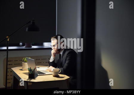 Müde männlichen Arbeitnehmers gähnen Ausgaben späten Stunden im Büro Stockfoto