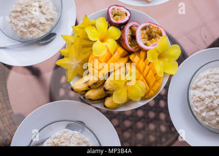 Gesund Sommer Frühstück Konzept. Bunte Fruit Smoothie Schale mit frischen, rohen Obst und Haferflocken Schalen. Ansicht von oben, horizontal Stockfoto