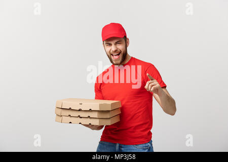 Lieferung Konzept: stattliche Pizza Delivery Man Kurier in roter Uniform mit Mütze holding Pizzakartons. Auf weiß isoliert. Stockfoto