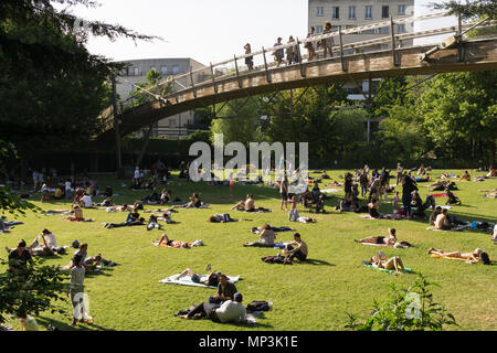 Menschen entspannen und genießen die Sonne am Quai De La Paul Permin Park an einem sonnigen Nachmittag in Paris. Stockfoto