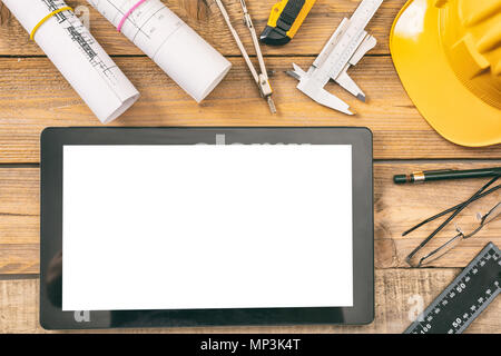 Architekten Arbeitsplatz und Technologie. Tablet mit weißen leeren Bildschirm, Projekt Bauplänen und Engineering Tools auf hölzernen Schreibtisch, kopieren, Stockfoto