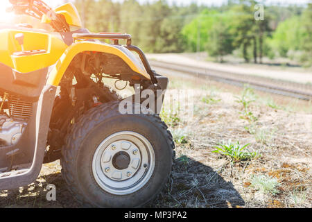 Close-up ATV oder quad bike Rad steht auf dem Hügel. Wunderschöne Landschaft Landschaft mit den Eisenbahnunternehmen für den Hintergrund. Extreme Reisen und Abenteuer Konzept Stockfoto