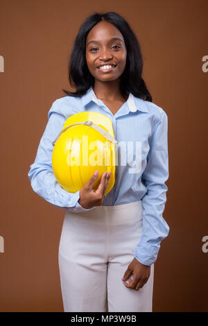 Junge schöne afrikanische Zulu Geschäftsfrau mit hardhat gegen Stockfoto