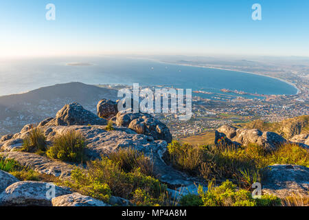 Stadtbild und Landschaft von Kapstadt bei Sonnenuntergang mit dem Indischen Ozean vom Table Mountain National Park aus gesehen, Südafrika. Stockfoto