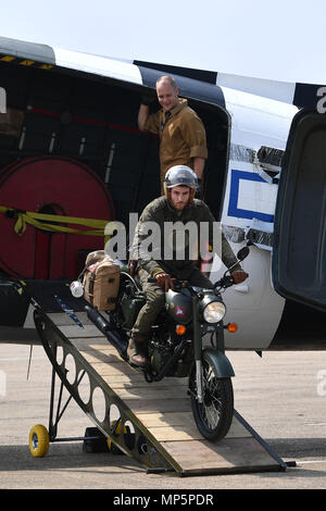 Eine neue limited edition Royal Enfield "Classic 500cc Pegasus' Motorrad inspiriert durch das Erbe des Royal Enfield WD/RE 125 cc bekannt als die 'Flying Flea' aus einem Dakota C-47 während seiner Enthüllung im Imperial War Museum Duxford geritten wird. Stockfoto