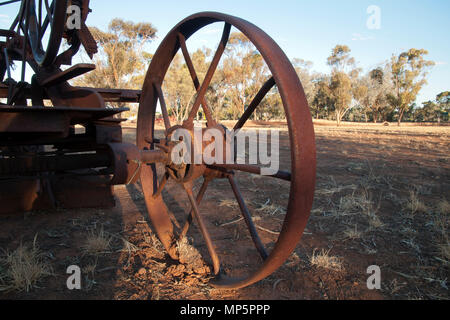 Quorn South Australia, Blick auf das Feld durch Rad von veralteten landwirtschaftliche Geräte links am Nachmittag Licht zu Rost Stockfoto