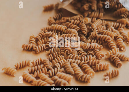 Vollkorn Pasta Fusilli von organischen Ganzen Dinkel Fallen von einer Papiertüte Stockfoto