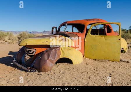 Rote und gelbe aufgegeben Classic Car in der Namib Wüste in der Nähe von Solitaire, Namibia Stockfoto