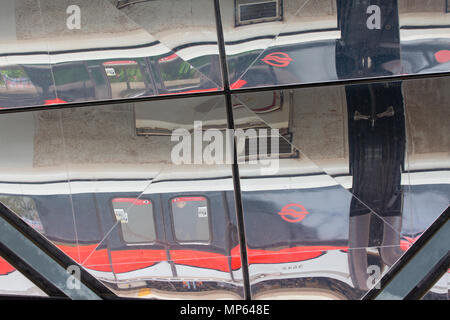 Draufsicht eines SMRT-Zuges, der an einem Bahnhof vorbeifährt. Singapur. Stockfoto