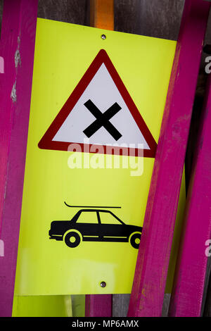 Schild gefährliche Kreuzung mit Auto und Ski-Rack und Polen in Lagerung im Skigebiet Stockfoto