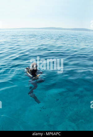 Scuba Diver auf der Oberfläche der Adria in Kroatien. Long Shot. Horizont über Wasser. Stockfoto