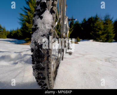 Mountainbike im Schnee, Sonne, blauen Himmel. Winter Fahrrad Ausbeutung in den Bergen Stockfoto