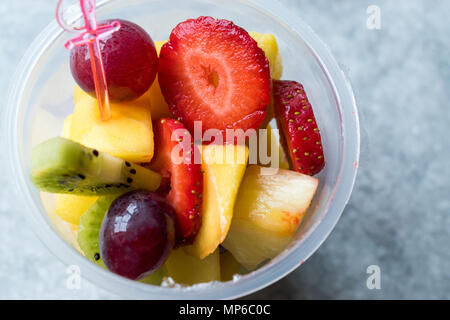 Obst Salat mit Erdbeeren, Kiwi, Mango und Traube in Plastikbecher. Ökologische Lebensmittel. Stockfoto