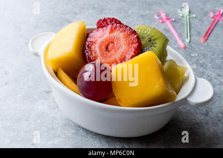 Mini Obst Salat mit Erdbeeren, Kiwi, Mango und Traube in weißer Keramik Schüssel. Ökologische Lebensmittel. Stockfoto