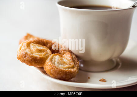 Palmier Cookies mit Kaffeetasse. Dessert Konzept. Stockfoto