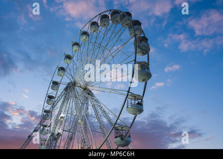 Ein Riesenrad, oder Big Wheel, bei einer Messe vor blauem Himmel. Stockfoto