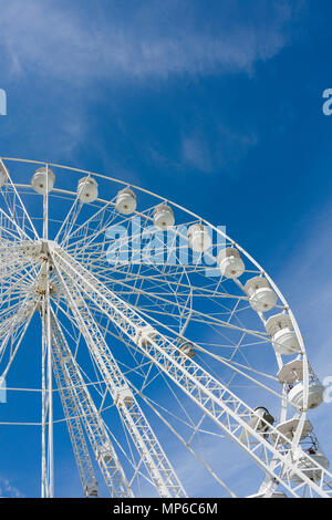 Ein Riesenrad, oder Big Wheel, bei einer Messe vor blauem Himmel. Stockfoto