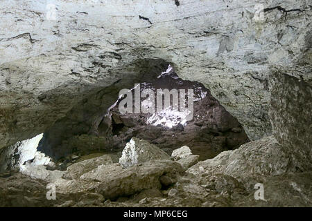 Hälfte - mit Rock und Lehm natürliche Höhle gefüllt. Nach dem Zusammenbruch der Tropfsteinhöhle, Steinschlag. Stockfoto