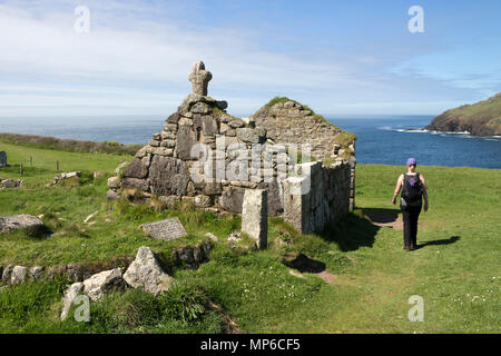 Der Wanderer und die Überreste von St Helen's Oratory, Cape Cornwall, UK. Stockfoto