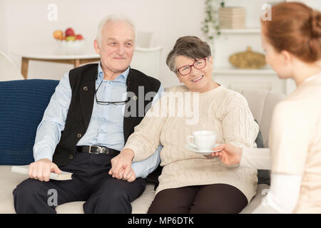 Schönes älteres Ehepaar bei einem Treffen mit ihrer Enkelin Stockfoto