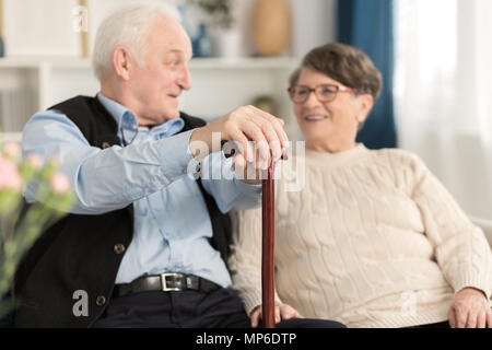 Älterer Mann mit einem Stock im Gespräch mit seiner Frau Stockfoto