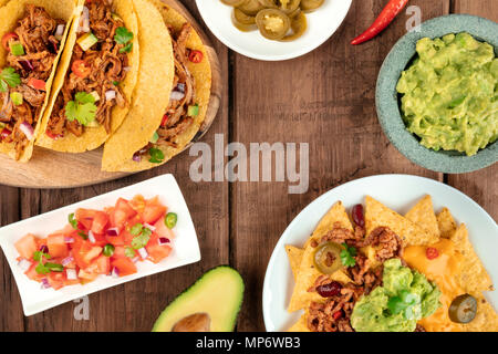 Ein Foto von einem ssortment vieler verschiedener mexikanische Lebensmittel, wie Tacos, Guacamole, Pico de Gallo, Nachos und andere, mit Kopie Raum Stockfoto