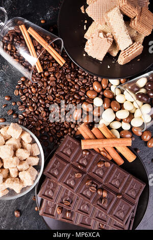 Blick von oben auf die braunen Zucker, Schokolade Tabletten und Zimtstangen Stockfoto