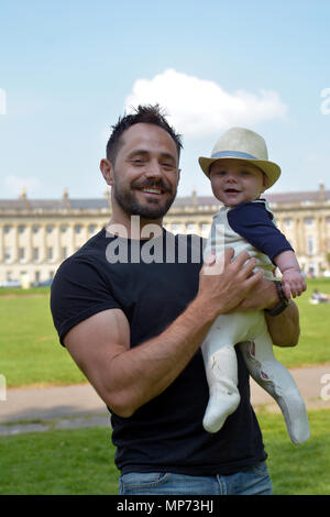 UK Wetter. Oskar und sein Sohn Noah, 8 Monate alt, ist mit einem Dab von Sonnencreme auf die Nase an der Rasen der Welt berühmte Bath Royal Crescent mit 30 Reihenhäusern in einer geschwungenen Surround geknallt. Robert Timoney/Alamy/Live/Aktuelles Stockfoto