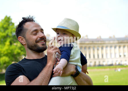 UK Wetter. Oskar und sein Sohn Noah, 8 Monate alt, ist mit einem Dab von Sonnencreme auf die Nase an der Rasen der Welt berühmte Bath Royal Crescent mit 30 Reihenhäusern in einer geschwungenen Surround geknallt. Robert Timoney/Alamy/Live/Aktuelles Stockfoto