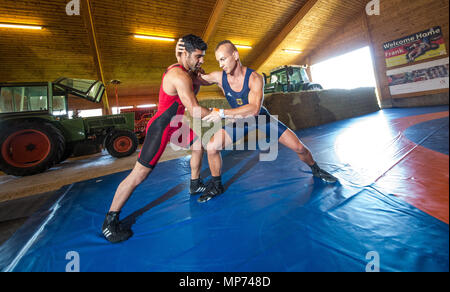 21. Mai 2018, Deutschland, Leinfelden-Echterdingen: Wrestling World Champion Frank Stäbler (R) Ausbildung auf einen Wurf Technik mit seinen trainingspartner Mohammad Papi in einem ehemaligen Kuhstall im Stadtteil Musberg. Aufgrund eines internen Streit in seinem lokalen Fitnessstudio, TSV Musberg, den 28-jährigen Ringkämpfer gezwungen worden, hat sich für die Wm vorzubereiten, in Budapest Ende Oktober stattfinden, in einem ehemaligen Kuhstall auf dem Bauernhof seiner Eltern. Foto: Christoph Schmidt/dpa Stockfoto