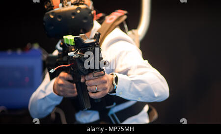 Stuttgart, Deutschland. 15 Mai, 2018. 15. Mai 2018, Deutschland, Stuttgart: ein EnterVR Mitarbeiter mit Hilfe der Firma VR-Schild Trainingssimulator während der ITEC-Messe für Militär und Waffen Technik. Credit: Sebastian Gollnow/dpa/Alamy leben Nachrichten Stockfoto