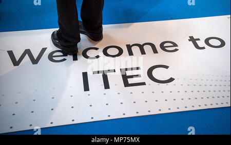 15. Mai 2018, Deutschland, Stuttgart: Ein Mann stand auf ein Band mit dem Text "Willkommen bei ITEC' während der ITEC-Messe für Militär und Waffen Technik. Foto: Sebastian Gollnow/dpa Stockfoto