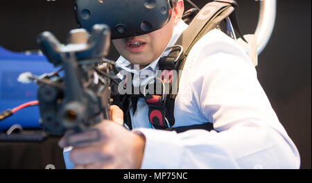 Stuttgart, Deutschland. 15 Mai, 2018. 15. Mai 2018, Deutschland, Stuttgart: ein EnterVR Mitarbeiter mit Hilfe der Firma VR-Schild Trainingssimulator während der ITEC-Messe für Militär und Waffen Technik. Credit: Sebastian Gollnow/dpa/Alamy leben Nachrichten Stockfoto