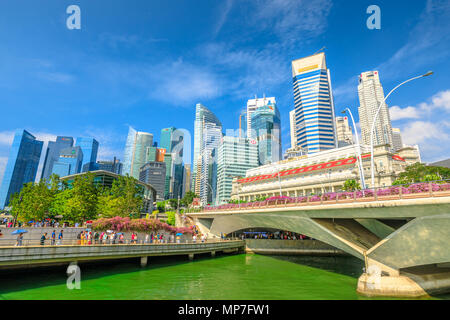 Singapur - 28. April 2018: Singapore Downtown Skyline mit Fullerton Hotel, Wolkenkratzer Business District, Esplanade Bridge und Menschen zu Fuß in der Marina Bay Promenade. Sonnigen Tag mit blauen Himmel. Stockfoto