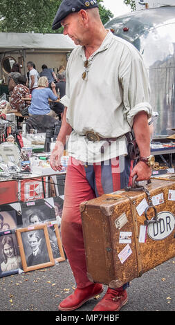 BERLIN, DEUTSCHLAND - 30. JULI 2016: Street Portrait eines gealterten Mann Berliner im schwarzen Barett mit einem alten Koffer auf einem Flohmarkt (Swap Meet, Rag fair) Stockfoto