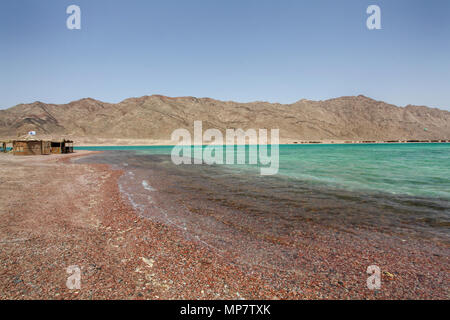 Einsame Strände an der Blauen Lagune (Dahab), Sinai, shanty Hütten Ägypten's Tourist im Hintergrund Stockfoto