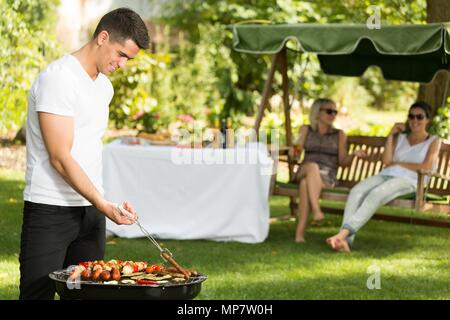 Jungen gutaussehenden Mann und Grill im Sommer am Nachmittag Stockfoto