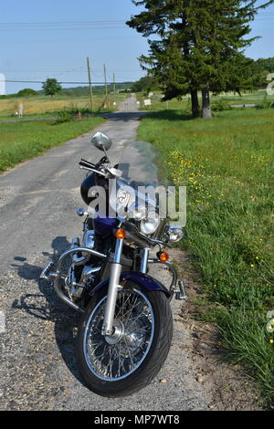Motorrad auf der Landstraße in einem Feld Stockfoto