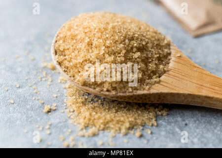 Brauner Zucker in Löffel aus Holz mit Paket. Ökologische Lebensmittel. Stockfoto