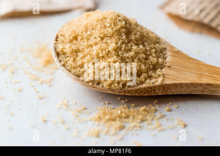 Brauner Zucker in Löffel aus Holz mit Paket. Ökologische Lebensmittel. Stockfoto