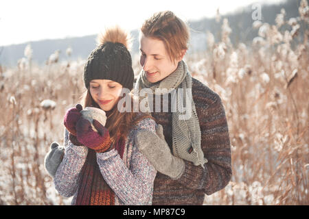Paar hat Spaß und lacht. Kuss. Junge hipster Paar umarmen in Winter Park. Winter Love Story, eine schöne stilvolle junges Paar. Winter Fashion Concept mit Freund und Freundin Stockfoto