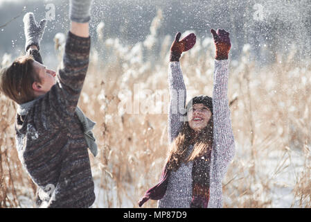 Paar hat Spaß und lacht. Kuss. Junge hipster Paar umarmen in Winter Park. Winter Love Story, eine schöne stilvolle junges Paar. Winter Fashion Concept mit Freund und Freundin Stockfoto