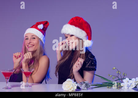 Freundinnen in Weihnachten Hüte mit Cocktails feiern das neue Jahr Stockfoto