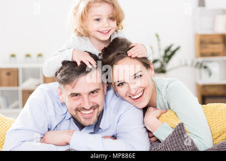 Schöne portrait einer fröhlichen Familie mit einer kleinen Tochter, lachen und spielen auf grossen Kissen Stockfoto